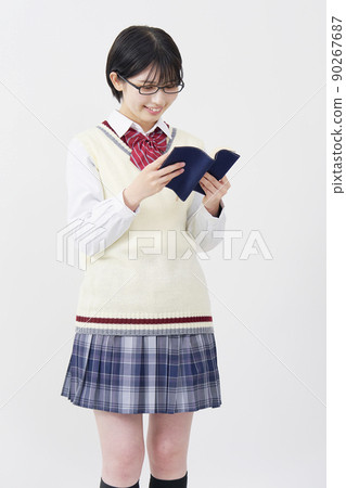 Schoolgirl reading a book on a white background Schoolgirl reading a book on a white background 90267687