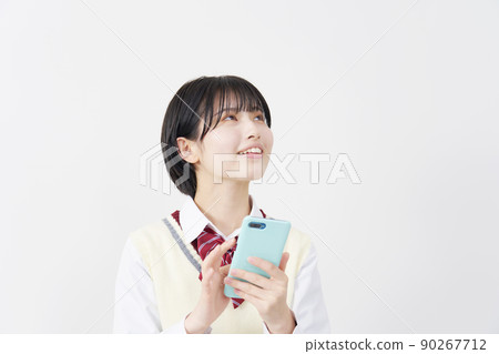 High school girl thinking while using a smartphone on a white background 90267712