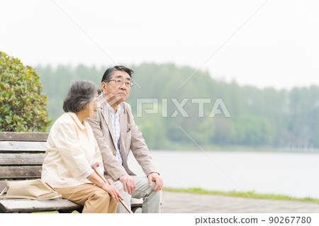 Senior couple sitting on a bench 90267780