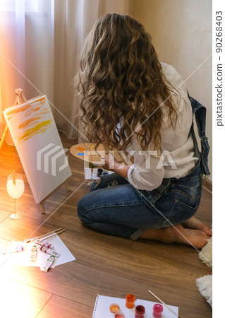 Creative painter in working process. Artist workplace, hobby, craft tools. Artist female canvas painting. Professional young woman painter draws in the workshop Creative painter in working process. Artist workplace, hobby, craft tools. Artist female canvas painting. Professional young woman painter draws in the workshop 90268403