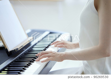 Japanese woman playing the piano in the living room 90269530