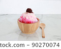 crushed ice Or shaved ice with sweet red water and sweetened condensed milk, Topped with red beans. in a round wooden bowl with wooden spoon. It is a dessert that is refreshing to eat. wooden spoon. 90270074