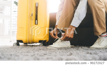 Asian tourism man hand tying shoelaces for begin a journey travel with luggage 90272027