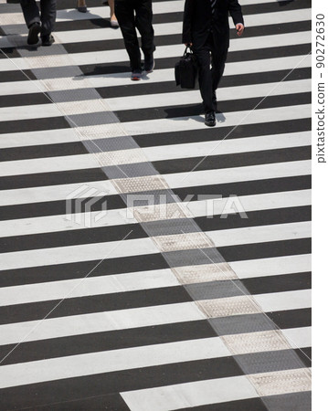 A bird's-eye view of people on a pedestrian crossing in the city center in summer A bird's-eye view of people on a pedestrian crossing in the city center in summer 90272630