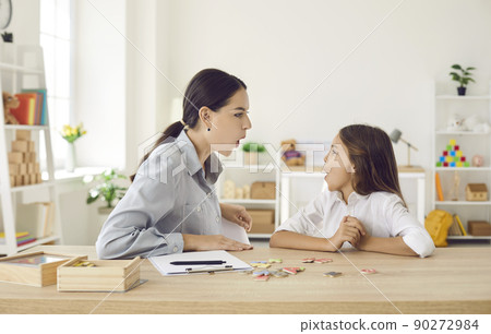 Kid and speech therapist doing articulation exercise to fix some pronunciation problems Kid and speech therapist doing articulation exercise to fix some pronunciation problems 90272984