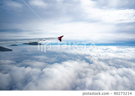 Aircraft wing above beautiful clouds and blue sky 90273214