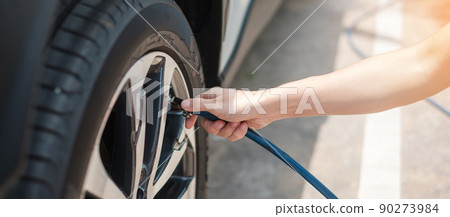 hand inflating tires of vehicle, checking air pressure and filling air on car wheel at gas station. self service, maintenance and safety transportation concept 90273984