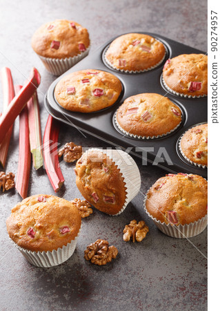Freshly baked muffins with rhubarb and walnuts close-up in a baking dish. Vertical Freshly baked muffins with rhubarb and walnuts close-up in a baking dish. Vertical 90274957