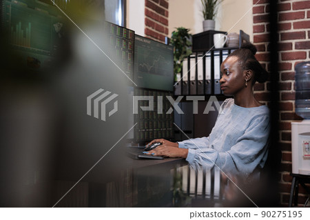 Hedge fund company agent trying to foretell bear market period using charts. Forex trading agent sitting at desk with multi monitor workstation while visualizing real time financial data on screens. 90275195