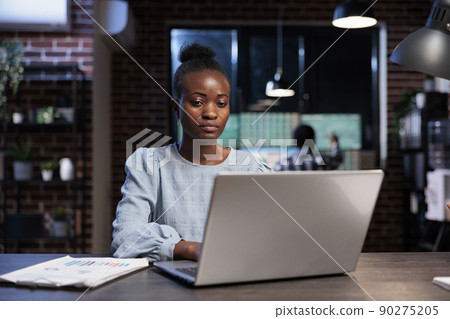 Hedge fund trading company professional employee sitting at desk while working on laptop to analyze financial data. Brokerage agent in office workspace, using computer to predict next market crash. Hedge fund trading company professional employee sitting at desk while working on laptop to analyze financial data. Brokerage agent in office workspace, using computer to predict next market crash. 90275205