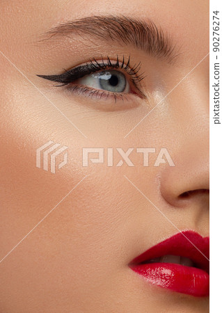 Beautiful brunet model woman face with green eyes and perfect make-up make smile on camera. Portrait of beauty with red lips and eyes liner, thick eyesbrow . Female face with clear skin close-up. Beautiful brunet model woman face with green eyes and perfect make-up make smile on camera. Portrait of beauty with red lips and eyes liner, thick eyesbrow . Female face with clear skin close-up. 90276274