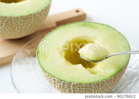 Scoop the Earl's melon cut in half with a spoon 90276622