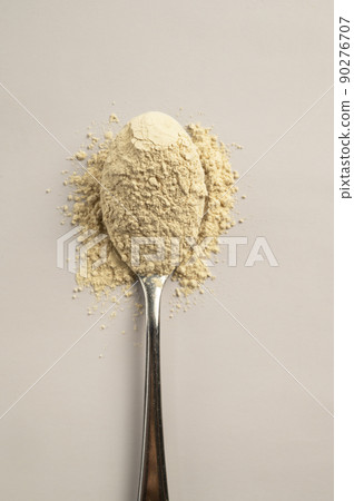 Heap of protein powder and a spoon with glass of water. Food supplements 90276707