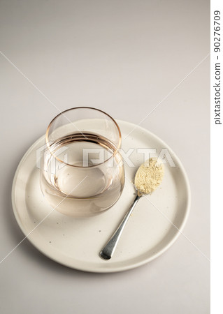 Protein powder and a spoon with glass of water. Food supplements Protein powder and a spoon with glass of water. Food supplements 90276709