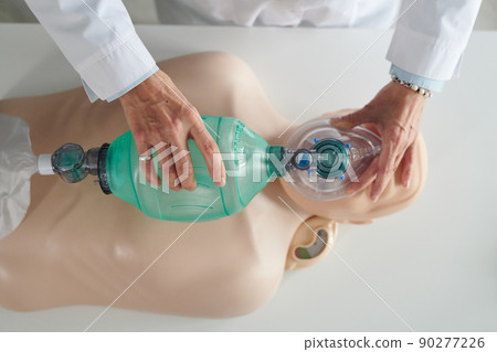 High angle view of medical worker learning to use breathing mask on CPR dummy 90277226