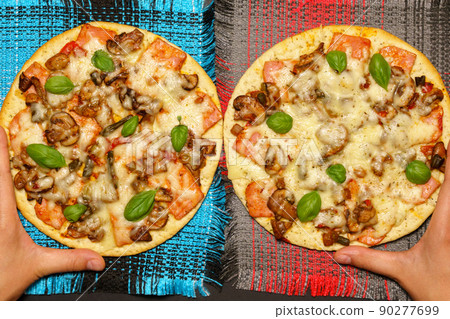 Round pizza top view with mushrooms and basil. On dark rustic background. Round pizza top view with mushrooms and basil. On dark rustic background. 90277699