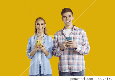 Happy couple uses mobile phone for online shopping, chatting, browsing media content or for games. Happy couple uses mobile phone for online shopping, chatting, browsing media content or for games. 90278139