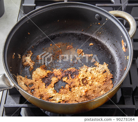 Burnt food in a pan of poor quality. Frying pan with non-stick coating, close-up 90278164