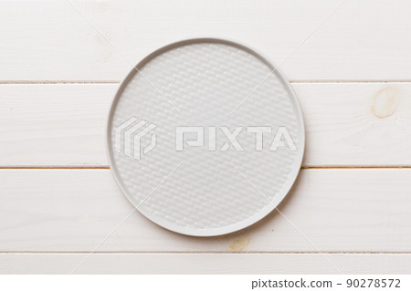 Top view of empty light plate on wooden background. Empty space for your design 90278572