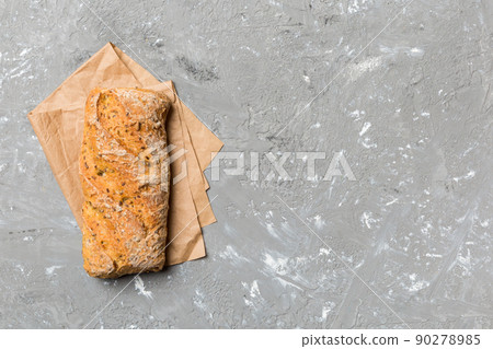 Fresh loaves of bread with wheat and gluten on a colored table. bread on napkin on rustic background, fresh bread top view 90278985