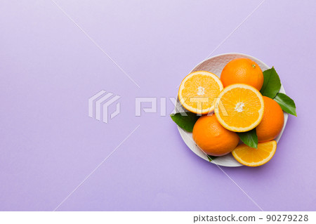 Flat lay of Fresh orange fruit with sliced in plate on Colored background. Top view with copy space Flat lay of Fresh orange fruit with sliced in plate on Colored background. Top view with copy space 90279228