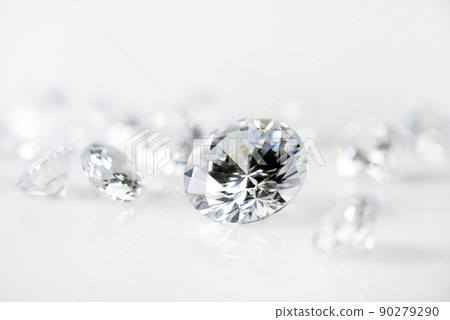 brilliant cut diamond held by tweezers on white background 90279290