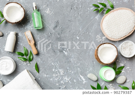 Coconut with jars of coconut oil and cosmetic cream on colored background. Top view. Free space for your text. Natural spa coconut cosmetics and organic treatment concept Coconut Spa composition 90279387