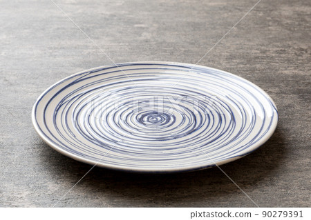 Perspective view of empty colorful plate on cement background. Empty space for your design Perspective view of empty colorful plate on cement background. Empty space for your design 90279391