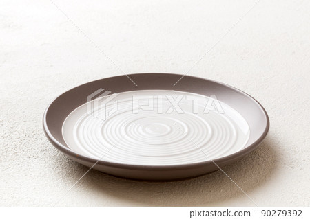 Perspective view of empty light plate on cement background. Empty space for your design Perspective view of empty light plate on cement background. Empty space for your design 90279392