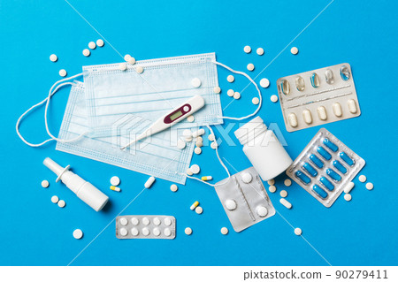 Protective face masks or surgical masks, medicine pills and thermometer on table background. Coronavirus disease. Corona virus concept. Space for text 90279411