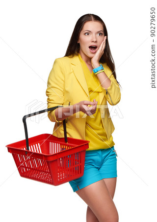 Surprised casual woman standing with empty shopping cart basket 90279650