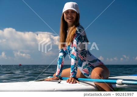 Healthy happy fit woman in bikini relaxing on a sup surfboard, floating on the clear turquoise sea water. Recreational Sports. Stand Up Paddle boarding. Summer fun, holidays travel. Active lifestyle 90281997