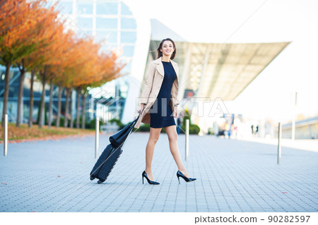 Woman near the airport with a suitcase is going on a trip Woman near the airport with a suitcase is going on a trip 90282597