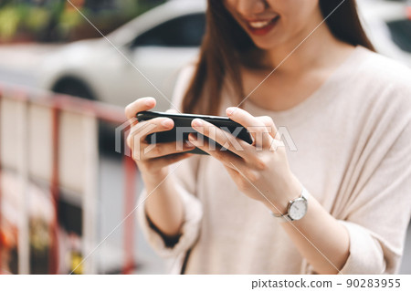 Woman holding smart phone connect online media via 5g internet 90283955