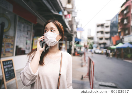 Casual business young asian single woman wear mask for new normal lifestyle in city 90283957