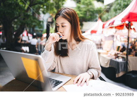 Business freelancer adult asian woman using laptop computer for work at sidewalk cafe 90283989