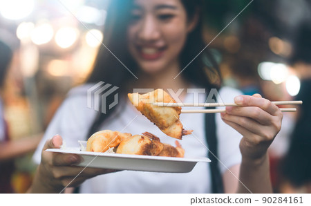 Closeup gyoza dish holding by happy asian woman. Closeup gyoza dish holding by happy asian woman. 90284161