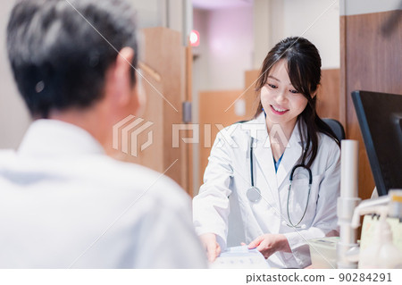 A female doctor who examines a male patient at the clinic 90284291