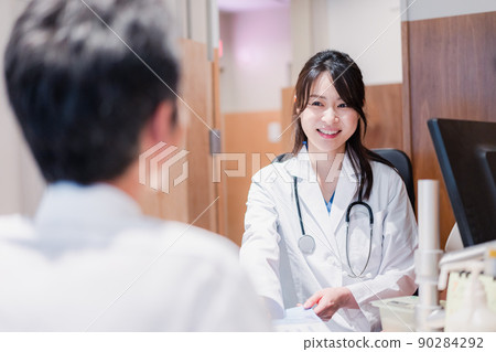 A female doctor who examines a male patient at the clinic A female doctor who examines a male patient at the clinic 90284292