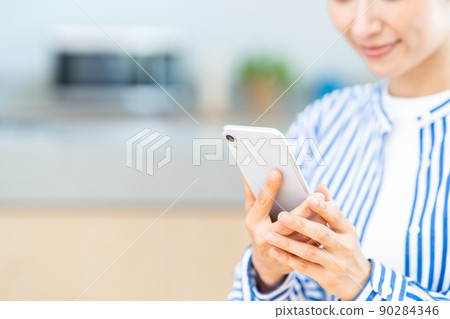 Middle-aged women (parts) who use smartphones in the living room 90284346