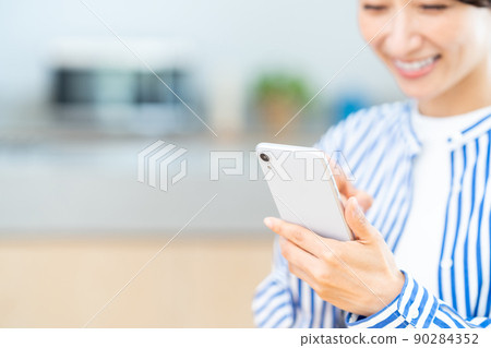 在客廳使用智能手機的中年女性（部分） 90284352