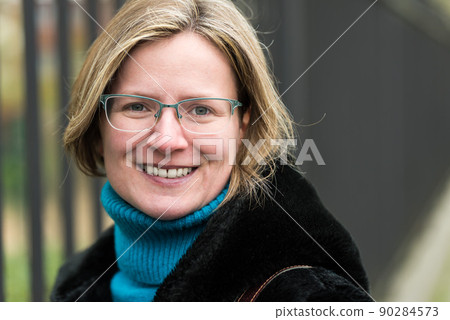 Portrait of a thirty year old white woman posing against an Industrial fence, wearing a black furry coat Portrait of a thirty year old white woman posing against an Industrial fence, wearing a black furry coat 90284573