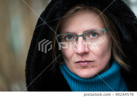 Headshot of a thirty year old white woman wearing a hoody, looking serious Headshot of a thirty year old white woman wearing a hoody, looking serious 90284576