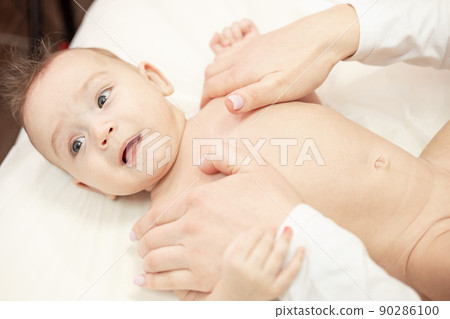 Female masseur doing baby massage for foot little infant baby child 90286100