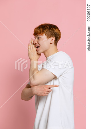 Portrait of young red-headed man in white t-shirt posing isolated over pink studio background. Concept of youth, fashion, emotions, facial expression Portrait of young red-headed man in white t-shirt posing isolated over pink studio background. Concept of youth, fashion, emotions, facial expression 90286507