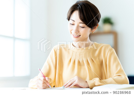 Middle woman studying in the living room Middle woman studying in the living room 90286968