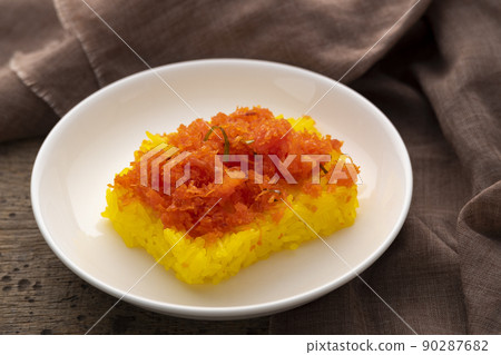 Yellow Gelatinous rice with shrimp topping on white plate 90287682