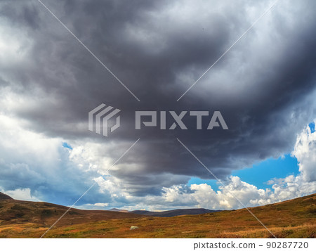 Terrible thunderclouds have hung over the autumn valley. The sky before a thunderstorm with thunderclouds. Terrible thunderclouds have hung over the autumn valley. The sky before a thunderstorm with thunderclouds. 90287720