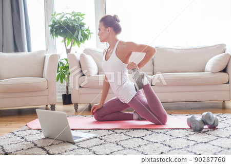 Young beautiful woman doing fitness exercises at home.  90287760