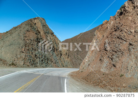 road in the mountains between the cliffs overlooking the snowy hills road in the mountains between the cliffs overlooking the snowy hills 90287875